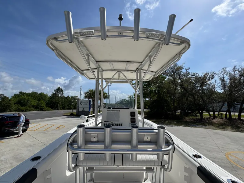 Slide: The Image of 2011 Sea Fox 236 Center Console boat with T-top and rod holders, parked outdoors. - 39