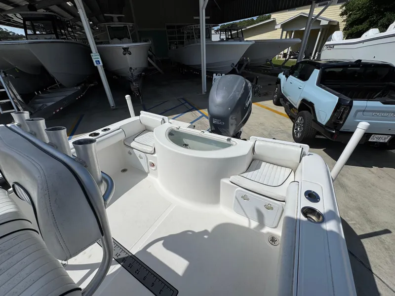 Slide: The Image of 2011 Sea Fox 236 Center Console boat with seating and motor, parked near vehicles. - 40