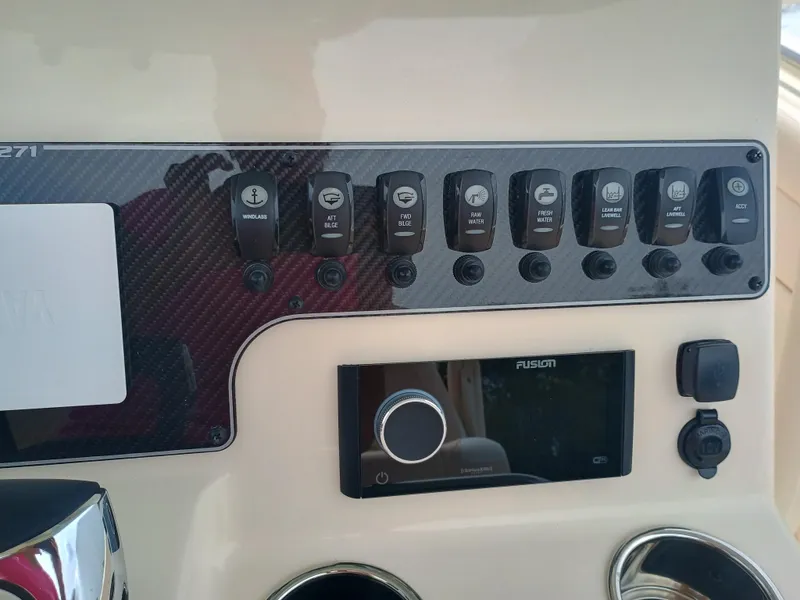 Slide: The Image of Control panel of 2025 Grady-White Canyon 271 boat with switches and Fusion audio system. - 13