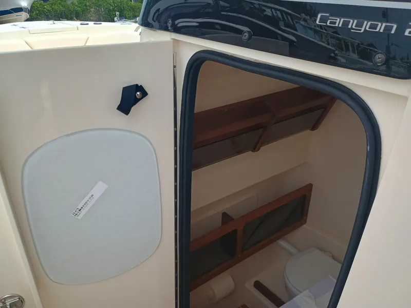 Slide: The Image of 2025 Grady-White Canyon 271 boat cabin interior with storage and toilet. - 22