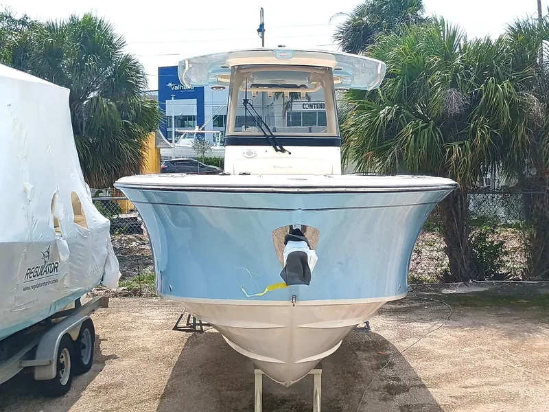 Slide: The Image of 2025 Grady-White Canyon 271 boat, front view, parked outdoors with palm trees in background. - 3