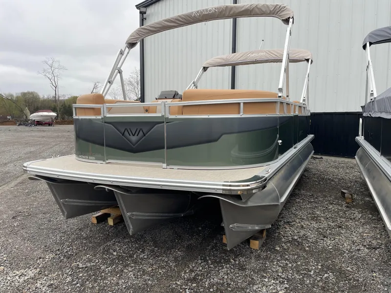 Slide: The Image of 2025 Tahoe Pontoon 2185 CRB boat with canopy, parked on gravel near a building. - 1