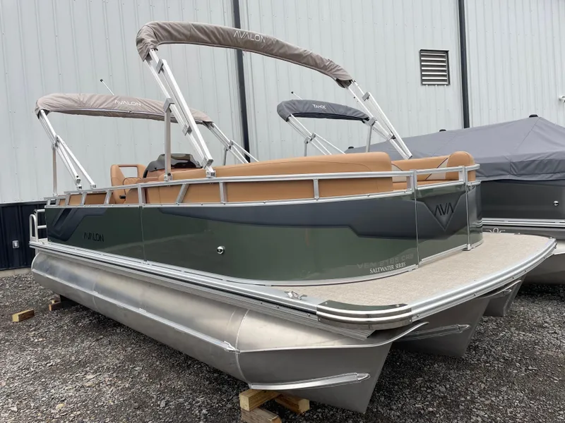 Slide: The Image of 2025 Tahoe Pontoon 2185 CRB, sleek design, green exterior, beige seating, docked on gravel. - 2