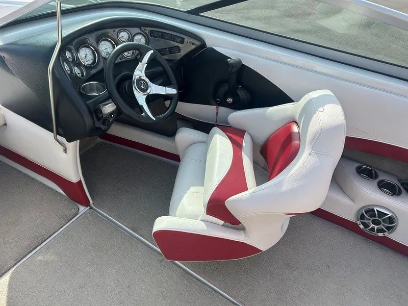 Slide: The Image of 2013 Crownline 21 SS boat interior with red and white seating, steering wheel, and dashboard controls. - 15