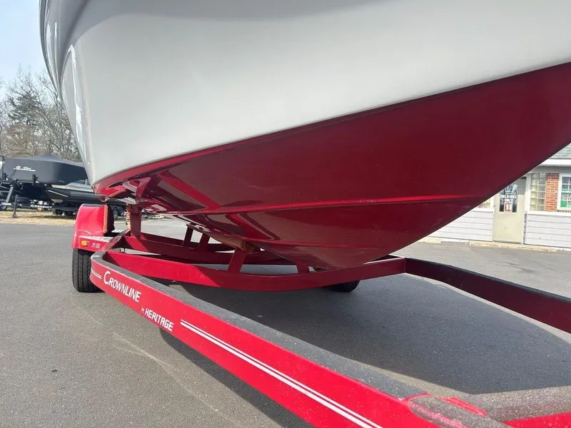 Slide: The Image of 2013 Crownline 21 SS boat on red trailer, parked outdoors. - 29