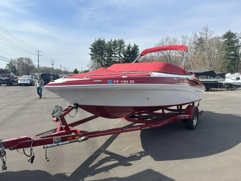 Slide: The Image of 2013 Crownline 21 SS boat with red cover on trailer in parking lot. - 5