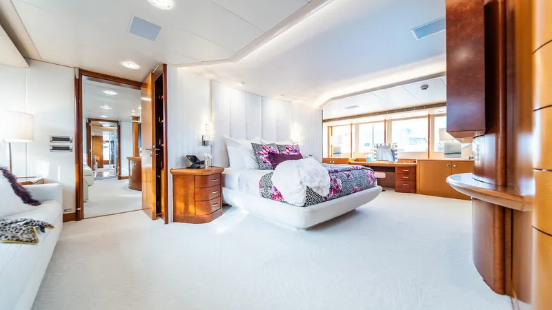 Slide: The Image of Luxurious bedroom interior on 1997 Feadship TASIA yacht, featuring elegant furnishings and large windows. - 10