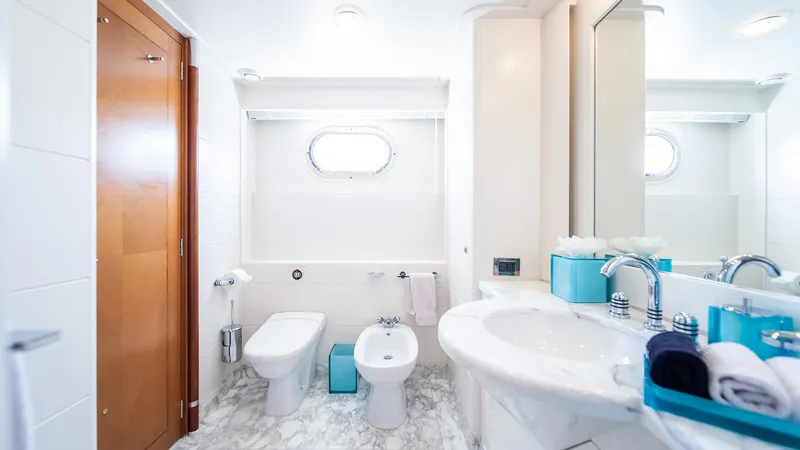 Slide: The Image of Luxurious yacht bathroom with modern fixtures, marble flooring, and porthole window on Feadship TASIA. - 38