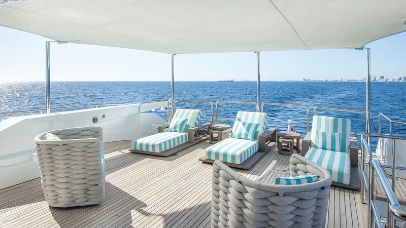 Slide: The Image of Luxurious deck of 1997 Feadship TASIA yacht with striped loungers and ocean view. - 48