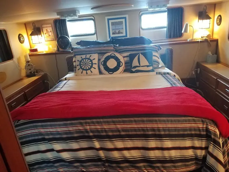 Slide: The Image of Cozy bedroom interior of 1986 Chris-Craft Constellation boat with nautical-themed decor. - 2