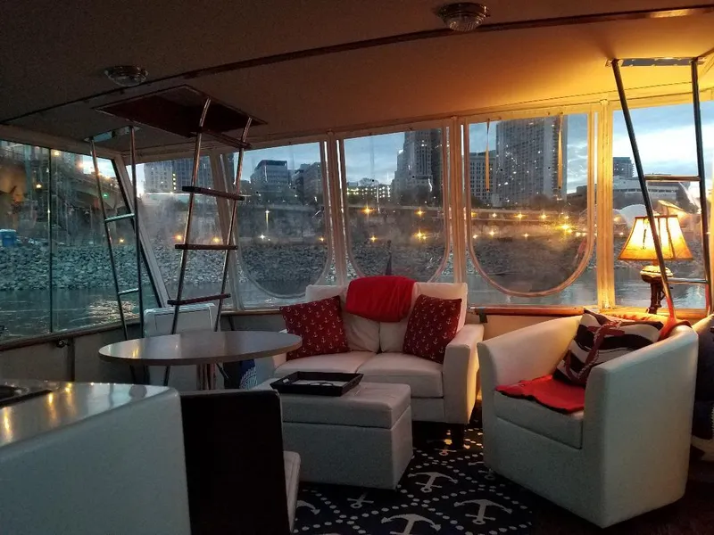 Slide: The Image of Interior of 1986 Chris-Craft Constellation yacht with cozy seating and cityscape view. - 4