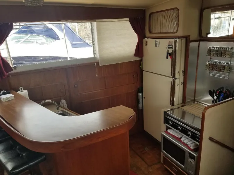 Slide: The Image of 1986 Chris-Craft Constellation yacht interior with kitchen, bar, and seating area. - 6