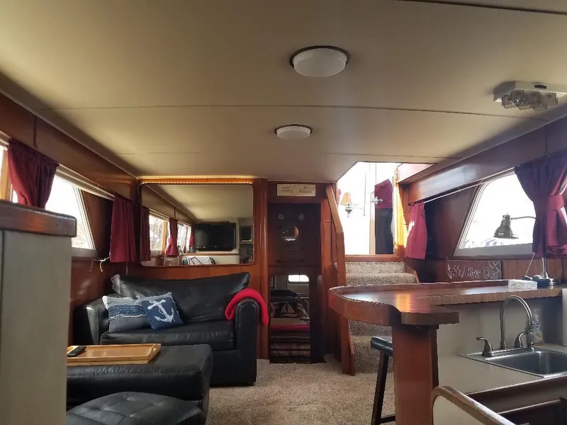 Slide: The Image of Interior of 1986 Chris-Craft Constellation yacht with cozy seating and wooden accents. - 8