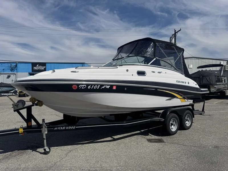 Slide: The Image of 2007 Four Winns 224 Funship boat on trailer, parked outdoors under cloudy sky. - 0