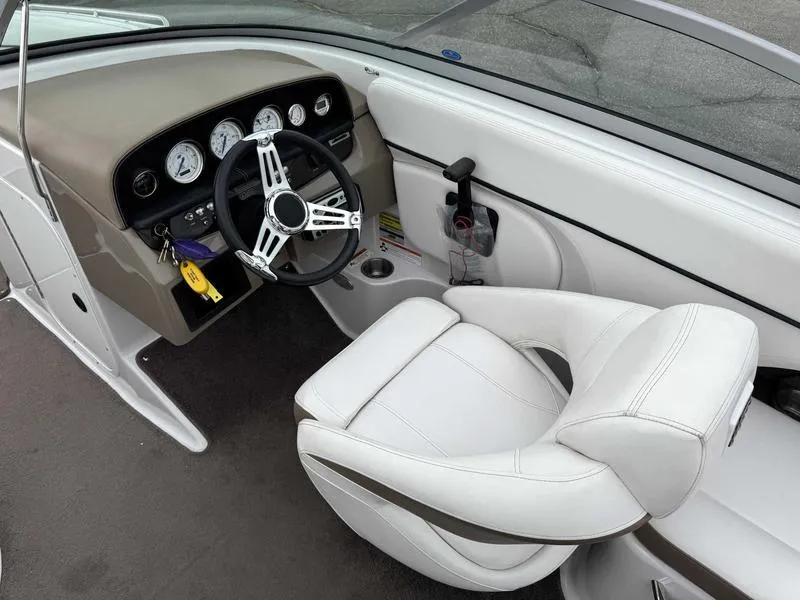 Slide: The Image of 2007 Four Winns 224 Funship boat interior with steering wheel and white captain's chair. - 11