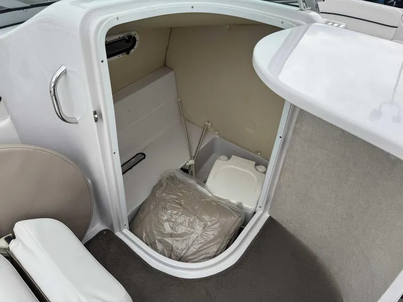 Slide: The Image of 2007 Four Winns 224 Funship boat interior with compact toilet and storage area. - 17