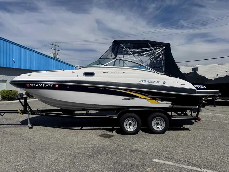 Slide: The Image of 2007 Four Winns 224 Funship boat on trailer, parked outdoors under cloudy sky. - 18