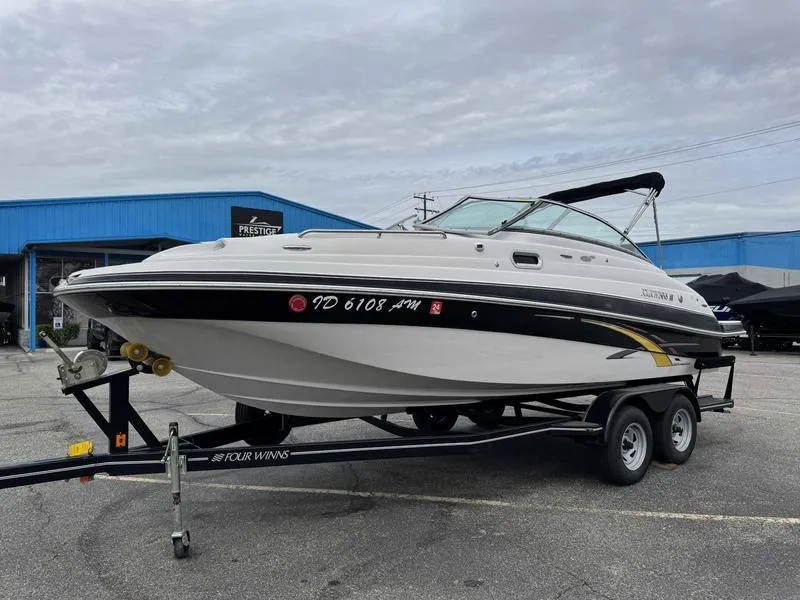 Slide: The Image of 2007 Four Winns 224 Funship boat on trailer, parked outdoors near blue building. - 4