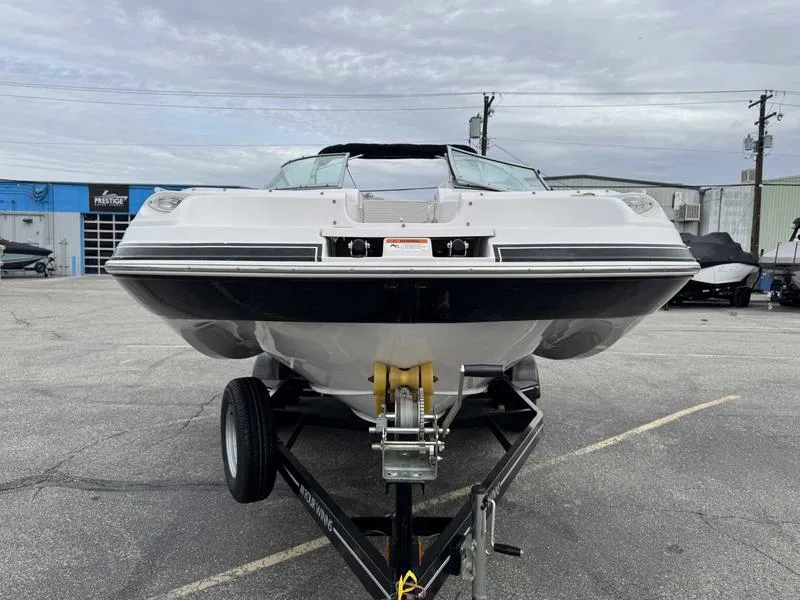 Slide: The Image of 2007 Four Winns 224 Funship boat on trailer, parked in a lot under cloudy skies. - 5