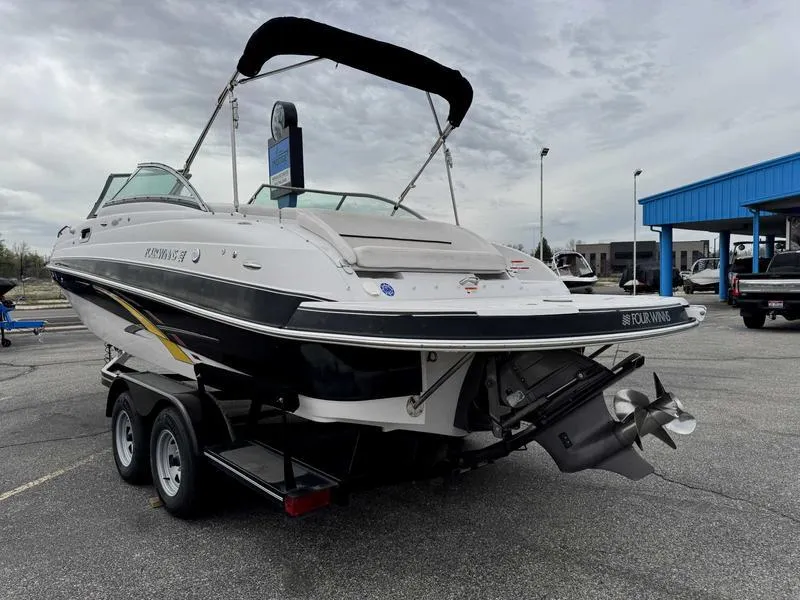 Slide: The Image of 2007 Four Winns 224 Funship boat on trailer, parked outdoors under cloudy sky. - 7