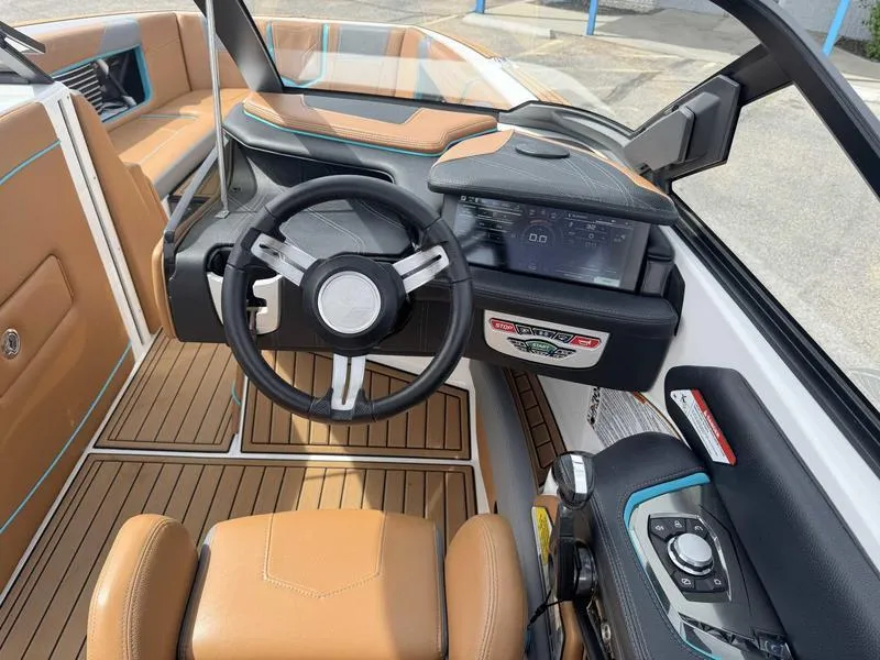 Slide: The Image of 2019 Nautique G25 boat interior with tan leather seats and modern dashboard. - 12