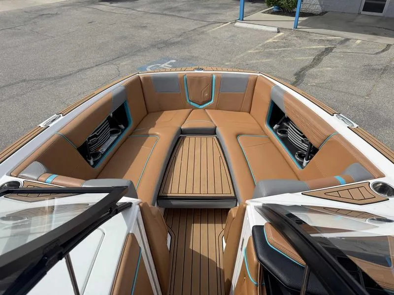 Slide: The Image of 2019 Nautique G25 boat interior with tan seating and teak flooring. - 13