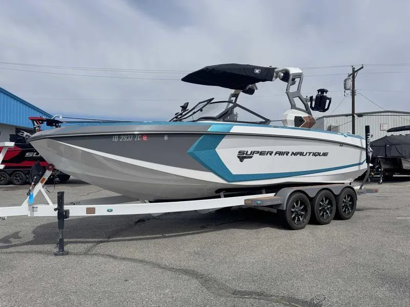 Slide: The Image of 2019 Nautique G25 boat on trailer, gray and blue design, parked outdoors. - 3