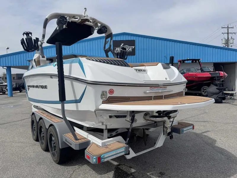 Slide: The Image of 2019 Nautique G25 boat on trailer, displayed outdoors near a blue building. - 6
