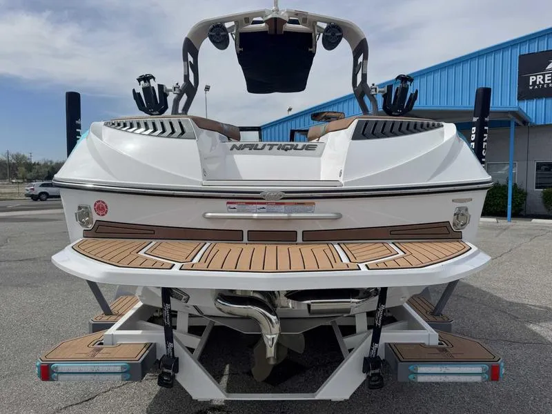 Slide: The Image of 2019 Nautique G25 boat rear view with teak deck, parked outdoors. - 7