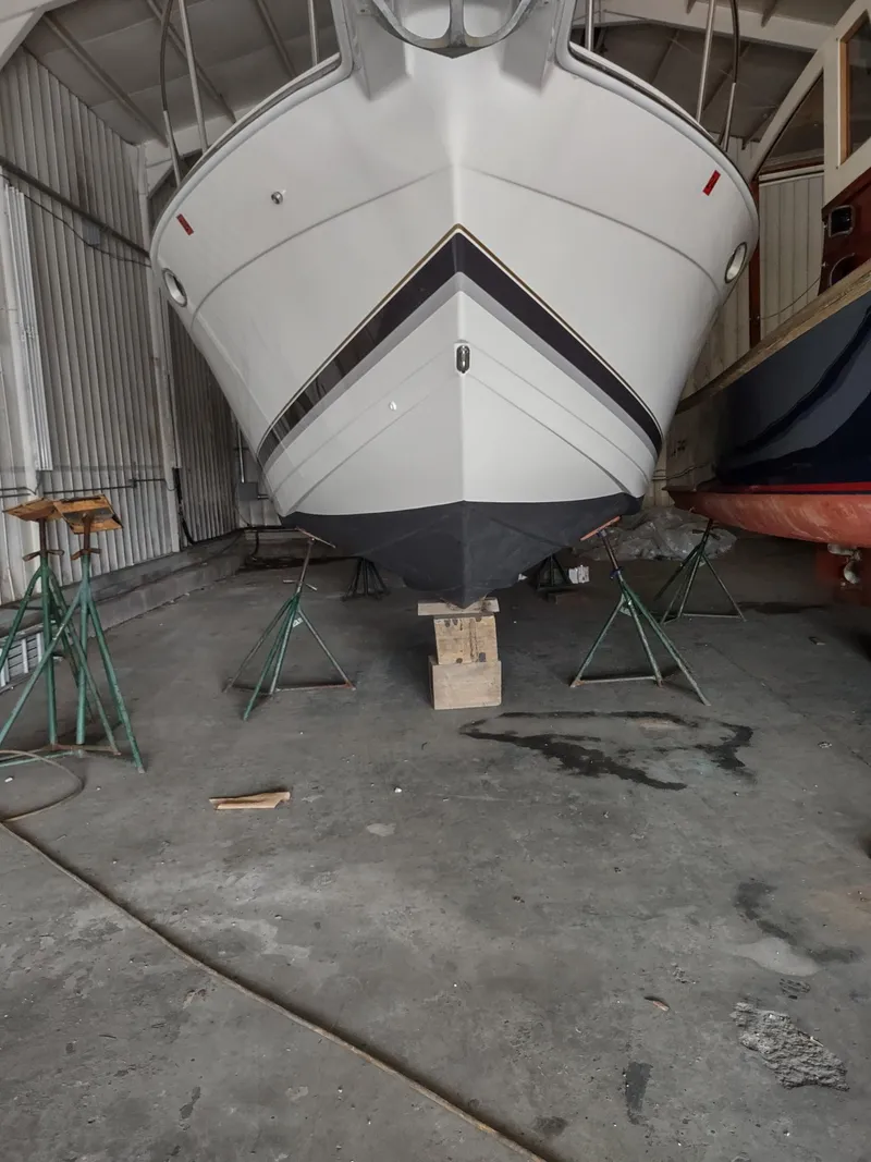 Slide: The Image of 2000 Formula 31PC boat in storage, supported by stands in a warehouse. - 17