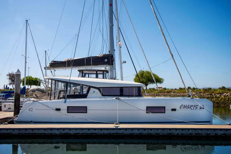 Slide: The Image of 2017 Lagoon 42 catamaran docked at marina under clear blue sky. - 11