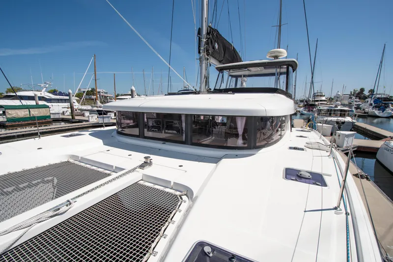 Slide: The Image of 2017 Lagoon 42 catamaran docked at a marina under clear blue skies. - 14