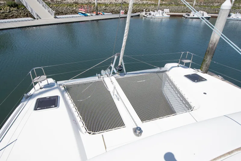 Slide: The Image of 2017 Lagoon 42 catamaran deck with netting, docked at marina. - 23