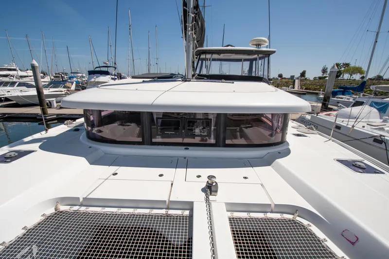 Slide: The Image of 2017 Lagoon 42 catamaran docked at marina, showcasing sleek design and spacious deck. - 25