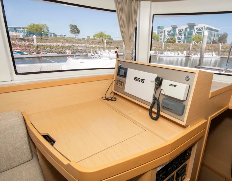 Slide: The Image of Interior view of a 2017 Lagoon 42 yacht with navigation equipment and marina background. - 37