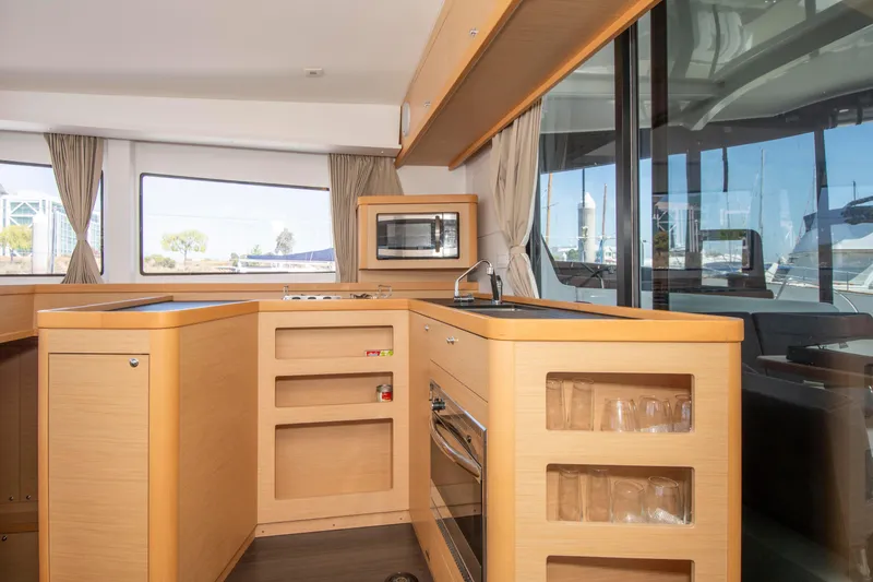 Slide: The Image of Interior of 2017 Lagoon 42 catamaran kitchen with modern appliances and wood finish. - 39