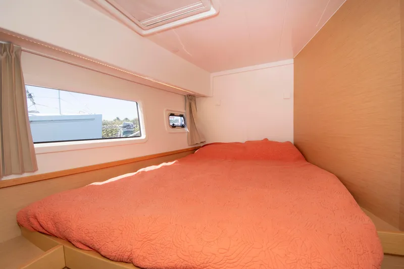 Slide: The Image of Cozy bedroom interior of 2017 Lagoon 42 catamaran with orange bedding and large window. - 45