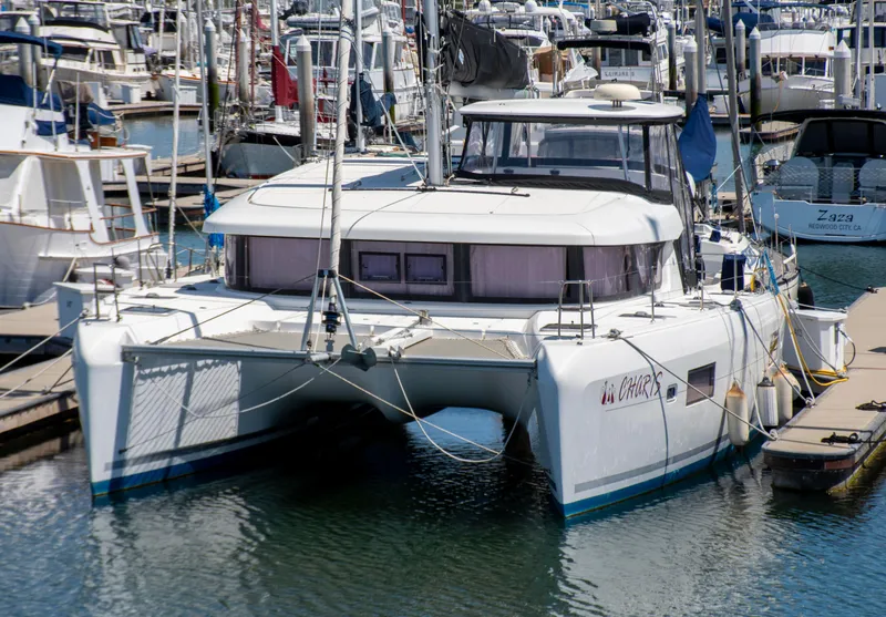 Slide: The Image of 2017 Lagoon 42 catamaran docked in a marina, surrounded by other boats. - 7