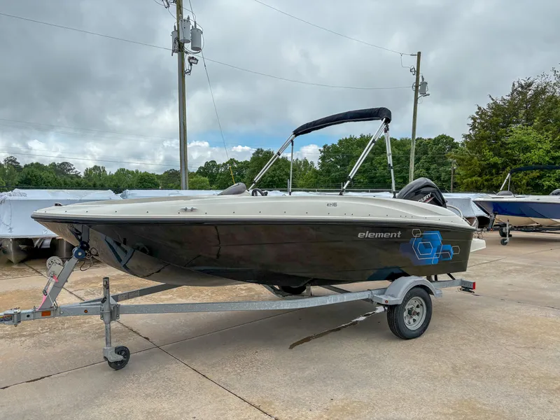Slide: The Image of 2020 Bayliner Element E16 boat on trailer, parked outdoors under cloudy sky. - 2