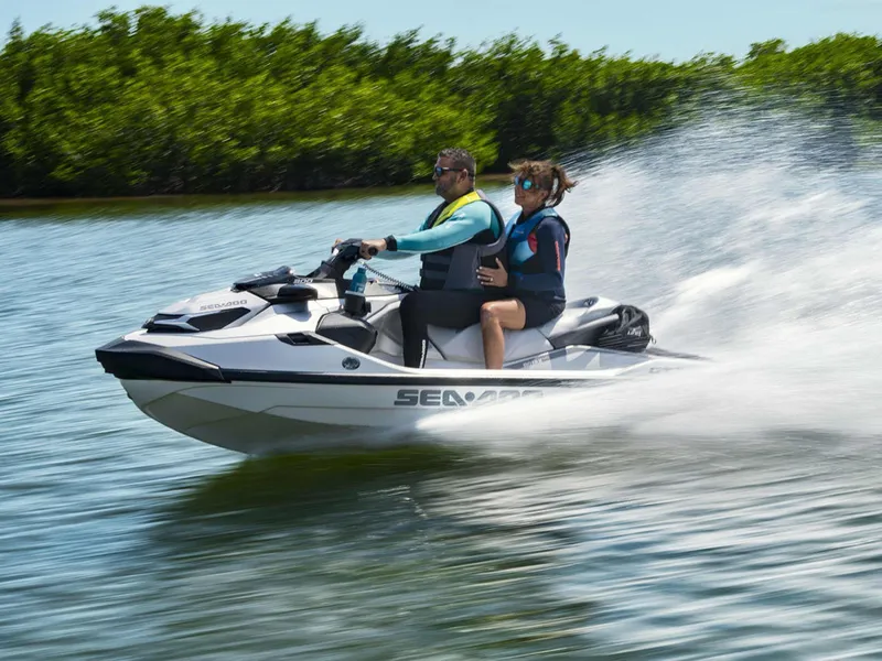 Slide: The Image of 2024 Sea-Doo GTX Limited 300 iDF jet ski speeding on water with two riders. - 11