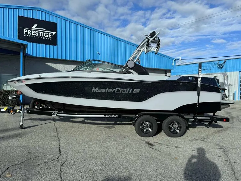 The Image of 2022 MasterCraft XT23 boat on trailer at Prestige Water Sports dealership. - 1