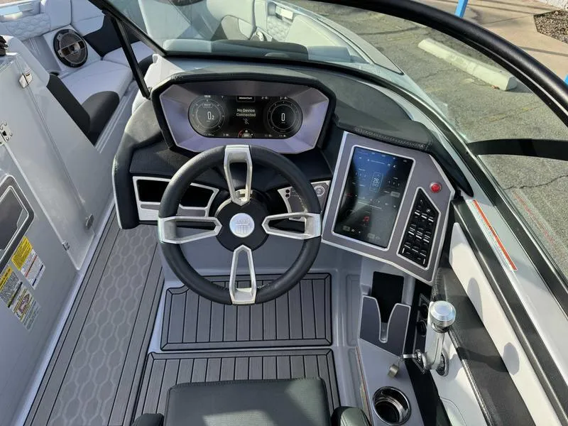 Slide: The Image of 2022 MasterCraft XT23 boat dashboard with modern controls and sleek steering wheel design. - 11