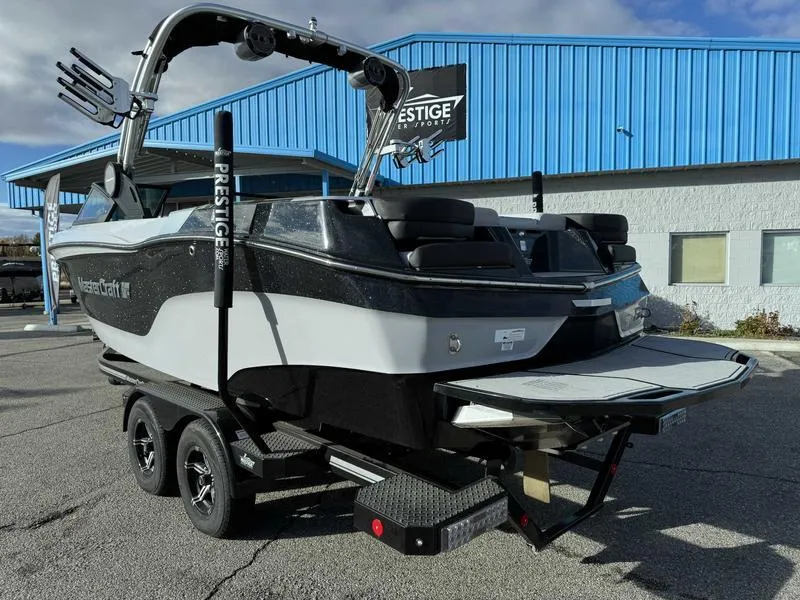 Slide: The Image of 2022 MasterCraft XT23 boat on trailer, parked outside a blue building. - 5