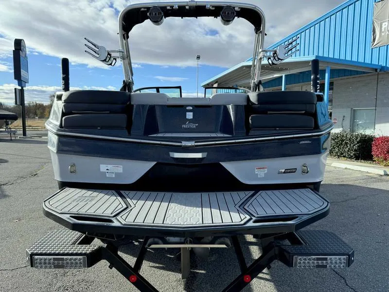Slide: The Image of 2022 MasterCraft XT23 boat rear view with swim platform and wakeboard racks. - 6