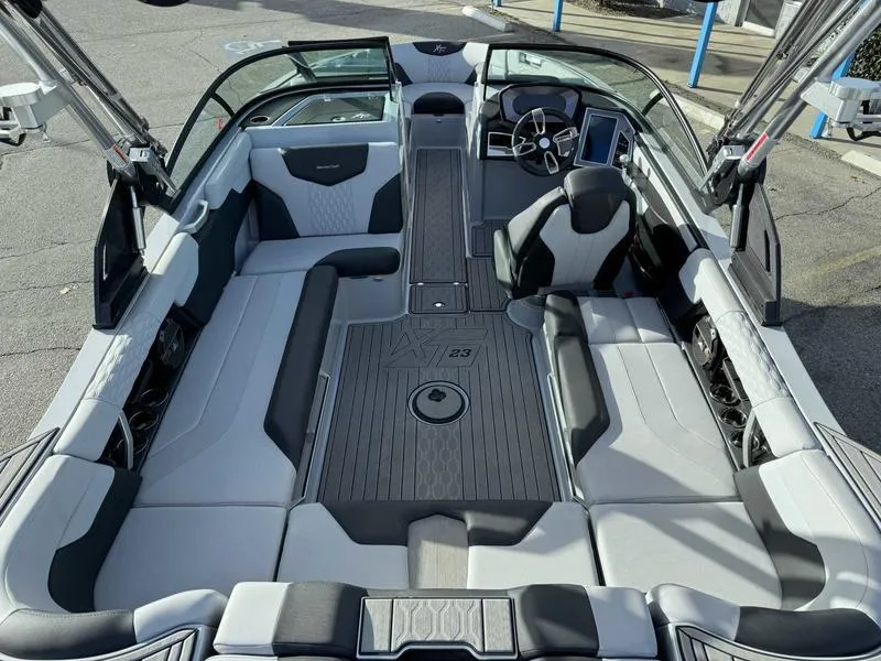 Slide: The Image of 2022 MasterCraft XT23 boat interior with sleek seating and modern dashboard design. - 9