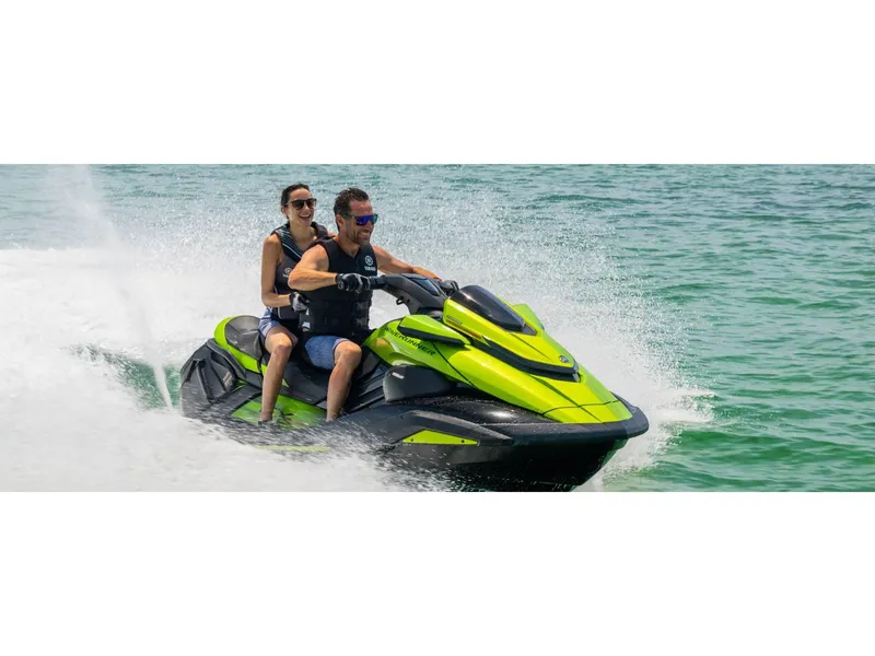 Slide: The Image of 2024 Yamaha FX Cruiser SVHO with Audio, vibrant green, on water with two riders enjoying the ride. - 7