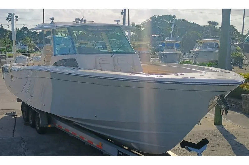 Slide: The Image of 2025 Grady-White Canyon 386 boat on trailer, parked outdoors in a marina setting. - 2