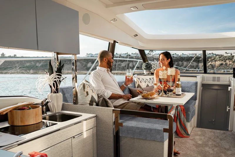 Slide: The Image of Couple enjoying a meal on a 2025 Prestige 420S yacht, with scenic ocean views. - 10