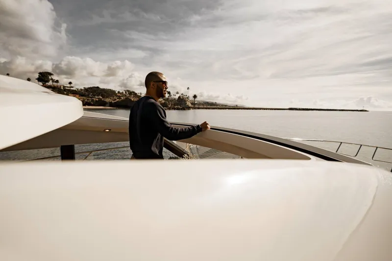 Slide: The Image of Man enjoying view on 2025 Prestige 420S yacht, calm sea, cloudy sky. - 15