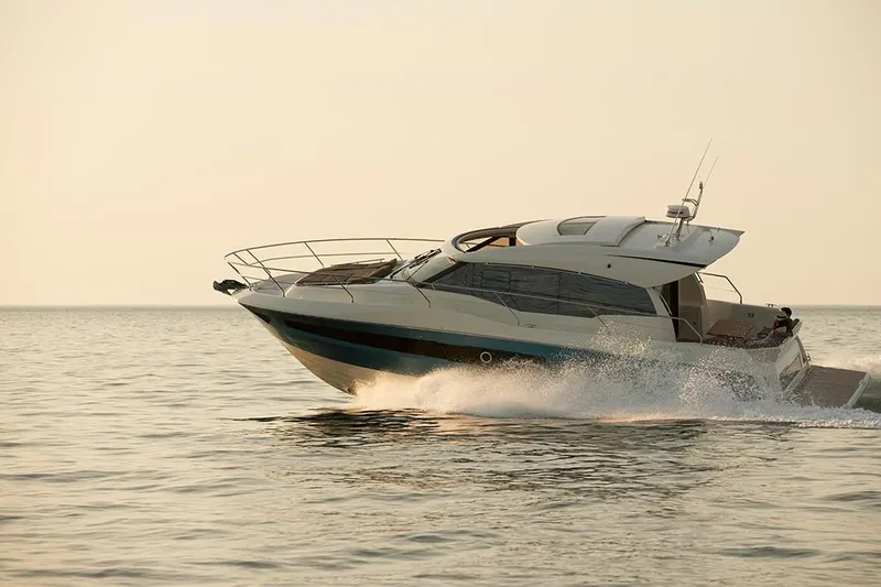 Slide: The Image of 2023 Prestige 460S yacht cruising on calm waters at sunset. - 9
